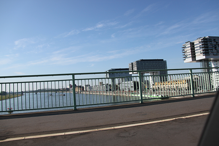 Blick von der Severinsbrücke (B55) nach Süden: die Poller Wiesen, die Südbrücke (Eisenbahn) und drei vorkragende Hochhäuser über die Straße „Im Zollhafen“ (Foto: B. Szilagyi 08/2015)